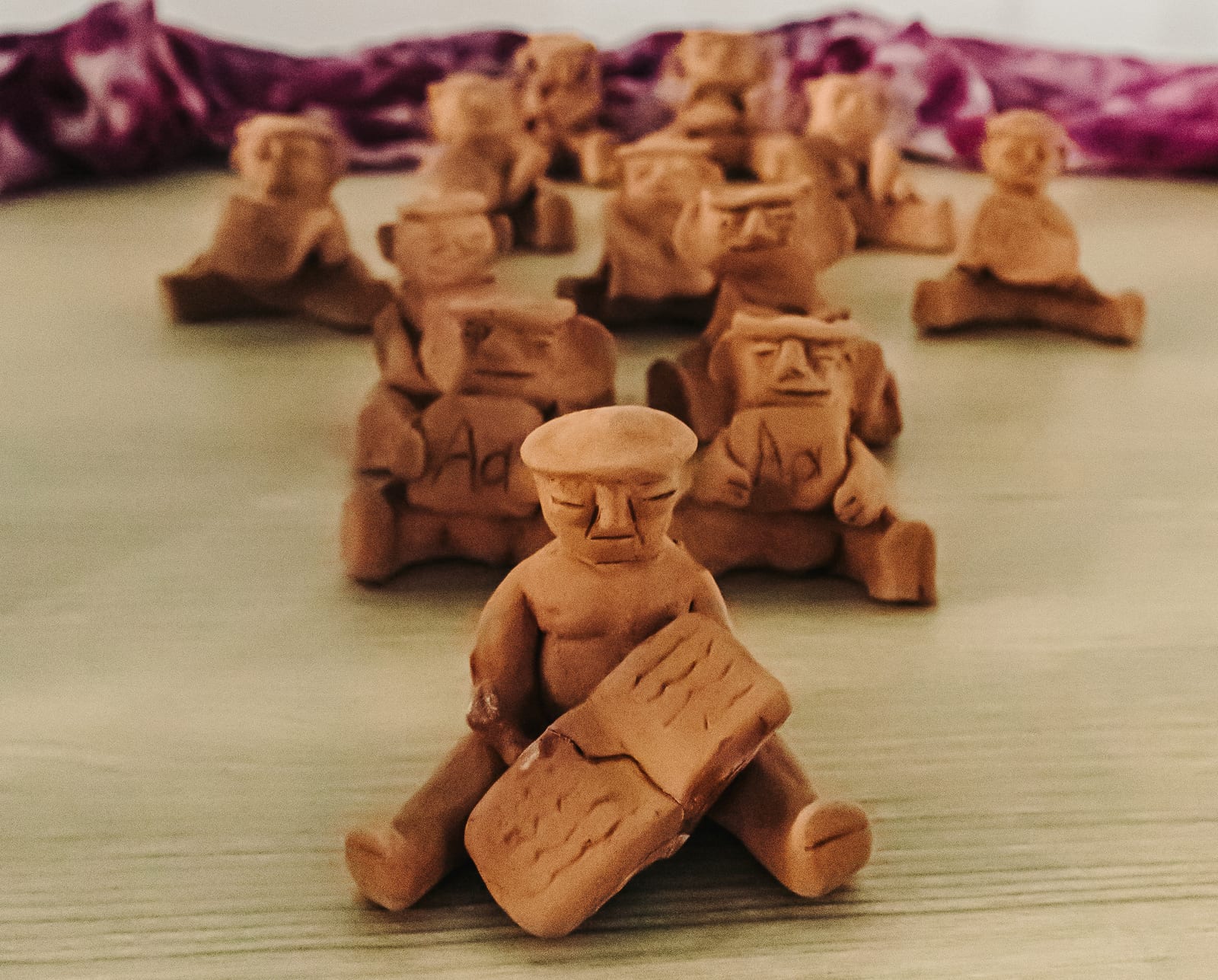 Figurines de barro con tela teñida de carmín